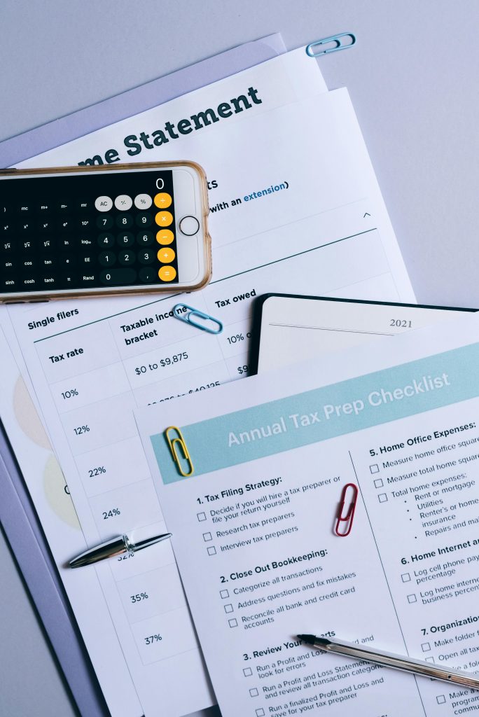 Flat lay of financial documents, tax checklist, and calculator for tax prep.